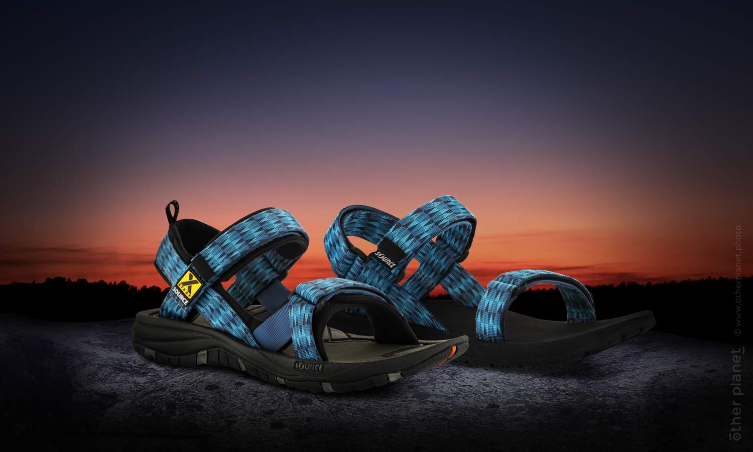 Source hiking sandals on sunset background